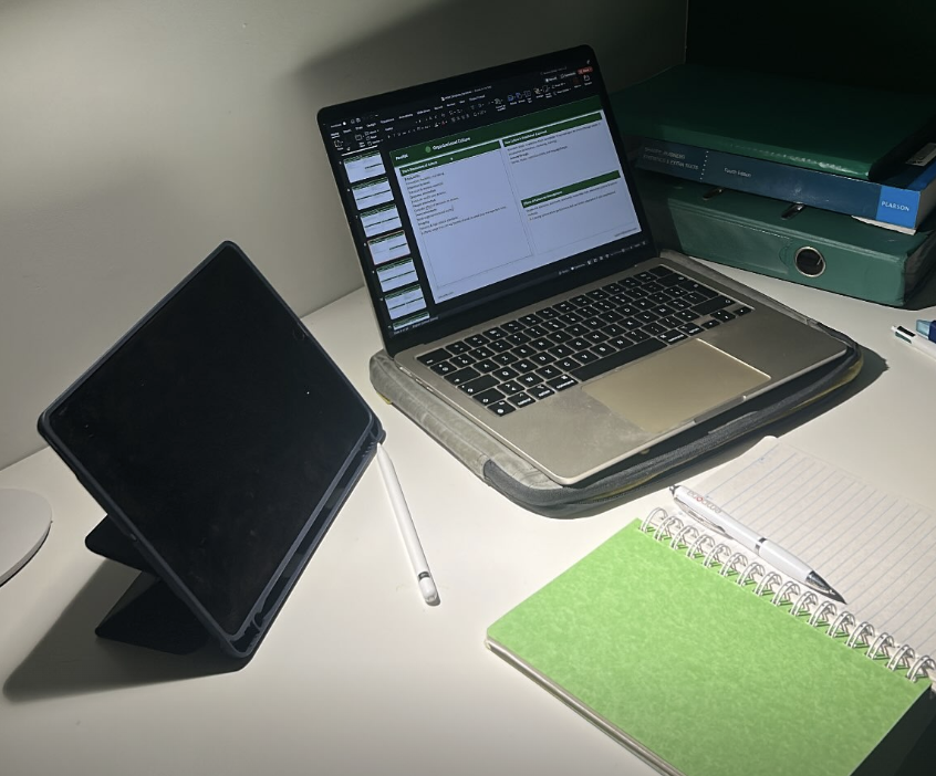 Study desk with laptop, tablet, and textbooks